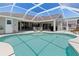 Beautiful pool area with a screened enclosure, comfortable seating, and a view of the home's exterior at 39 Medalist Ln, Rotonda West, FL 33947