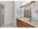 Bathroom with a vanity, wooden cabinets, a large mirror, and a glass door walk-in shower at 4115 Hemingway Dr, Venice, FL 34293