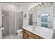 Bright bathroom features a shower, toilet, sink and large mirror at 4115 Hemingway Dr, Venice, FL 34293