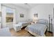 Bedroom with two twin wicker beds, light colored wood flooring, and a window with bright natural light at 4115 Hemingway Dr, Venice, FL 34293