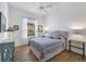 Cozy bedroom featuring a ceiling fan, wood flooring, and a queen size bed with blue patterned bedding at 4115 Hemingway Dr, Venice, FL 34293