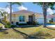 Charming one-story home with a well-manicured lawn and lush landscaping under a sunny blue sky at 4115 Hemingway Dr, Venice, FL 34293