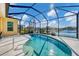 Screened-in pool with a view of a tranquil lake and well-maintained landscaping with blue skies at 4115 Hemingway Dr, Venice, FL 34293