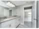 Bathroom with double sinks, granite countertops, a large mirror and wood-look tile at 5273 Gillot Blvd, Port Charlotte, FL 33981
