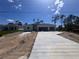 Newly built single-Gathering home with a three-car garage and freshly poured concrete driveway on a sunny day at 5273 Gillot Blvd, Port Charlotte, FL 33981