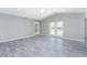 Spacious living room with vaulted ceilings, ceiling fan, gray wood-look tile flooring, and double doors to the yard at 5273 Gillot Blvd, Port Charlotte, FL 33981