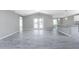 Large living room with vaulted ceilings, gray wood-look tile flooring, and access to the kitchen and dining areas at 5273 Gillot Blvd, Port Charlotte, FL 33981