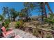 Inviting backyard with tiled patio, lush landscaping, and comfortable seating under mature trees at 6796 Gasparilla Pines Blvd # 63, Englewood, FL 34224