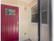 Welcoming front door with a beautiful red door and sidelight at 6796 Gasparilla Pines Blvd # 63, Englewood, FL 34224