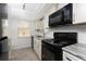 Updated kitchen featuring black appliances, stainless steel sink, and white cabinetry at 6796 Gasparilla Pines Blvd # 63, Englewood, FL 34224