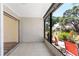 A cozy lanai space featuring tiled floors, sliding door access, and views of the outdoor landscaping at 6796 Gasparilla Pines Blvd # 63, Englewood, FL 34224