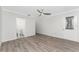 Bright living room featuring wood-look floors, modern ceiling fan, and an adjacent bathroom for added convenience at 6796 Gasparilla Pines Blvd # 63, Englewood, FL 34224