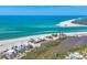 Expansive aerial view showcasing turquoise ocean, sandy beach, and luxury waterfront homes nestled in tropical landscape at 6890 Palm Island Dr, Placida, FL 33946