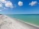 Expansive beach view with clear turquoise water, inviting for a refreshing dip on a sunny day at 6890 Palm Island Dr, Placida, FL 33946