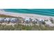 An aerial perspective capturing several beachfront homes, bordered by lush greenery and pristine ocean waters at 6890 Palm Island Dr, Placida, FL 33946