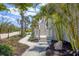 Attractive walkway leading to a charming beach house, surrounded by vibrant greenery and tropical palm trees at 6890 Palm Island Dr, Placida, FL 33946