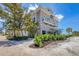 Charming coastal home featuring multiple balconies, lush tropical landscaping, and a serene beachfront setting at 6890 Palm Island Dr, Placida, FL 33946