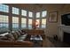 Cozy living room featuring a fireplace, TV, and large windows with sunset views over the ocean at 6890 Palm Island Dr, Placida, FL 33946