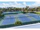 Tennis courts surrounded by well maintained greenery; ocean in the background, creating the perfect sports oasis at 6890 Palm Island Dr, Placida, FL 33946