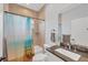 Full bathroom featuring tiled shower and bathtub with a beach themed shower curtain and granite vanity at 7332 Brandywine Dr, Englewood, FL 34224