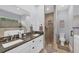 Modern bathroom featuring double sinks, granite counters, and a large walk-in shower and tub at 7332 Brandywine Dr, Englewood, FL 34224