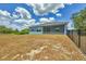 Rear exterior view of a well-maintained home with a spacious backyard and screened in lanai at 7332 Brandywine Dr, Englewood, FL 34224