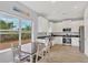 Bright kitchen with stainless steel appliances, white cabinets, and an adjacent dining area at 7332 Brandywine Dr, Englewood, FL 34224