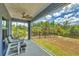 Relaxing screened-in lanai with outdoor furniture and view of the lush backyard and treeline at 7332 Brandywine Dr, Englewood, FL 34224