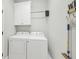 Laundry room featuring white washer and dryer and a storage cabinet for laundry supplies at 7332 Brandywine Dr, Englewood, FL 34224