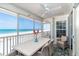 Screened-in patio boasts gulf views, a ceiling fan, and wicker furniture for relaxed outdoor living and dining at 7548 Palm Island S Dr # 1724, Placida, FL 33946