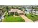 An aerial perspective showcasing a home with lush landscaping and a waterway behind the property at 8180 Burwell Cir, Port Charlotte, FL 33981