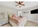 Comfortable bedroom boasts a ceiling fan, mounted TV, and charming decor at 8180 Burwell Cir, Port Charlotte, FL 33981