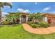Charming single-Gathering home featuring lush landscaping, a terracotta walkway, and a well-manicured lawn at 8180 Burwell Cir, Port Charlotte, FL 33981