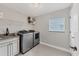 Well-equipped laundry room with modern washer and dryer, granite countertop, and built-in sink at 8180 Burwell Cir, Port Charlotte, FL 33981