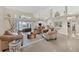 Open-concept living room with tile flooring, neutral tones, and sliding glass doors to the outdoor area at 8180 Burwell Cir, Port Charlotte, FL 33981