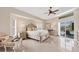 Bright main bedroom featuring a ceiling fan, and a private entrance to the pool area at 8180 Burwell Cir, Port Charlotte, FL 33981