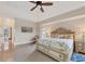 Large primary bedroom featuring a ceiling fan, tray ceiling and tile flooring at 8180 Burwell Cir, Port Charlotte, FL 33981