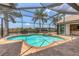 Enjoy the outdoors with a screened-in pool and spa overlooking the water at 8180 Burwell Cir, Port Charlotte, FL 33981