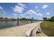 Picturesque view of a waterfront park with a bench, concrete seawall, and channel at 8180 Burwell Cir, Port Charlotte, FL 33981