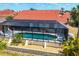 Overhead view of a private screened pool and lanai surrounded by meticulously maintained landscaping at 8320 Creekview Ln, Englewood, FL 34224