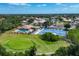 Aerial view showcasing a community pool, tennis courts, and a well-manicured golf course at 8320 Creekview Ln, Englewood, FL 34224