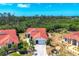 This aerial view showcases the house with its distinctive red tile roof and lush tropical landscaping at 8320 Creekview Ln, Englewood, FL 34224