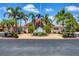 Clubhouse at Oyster Creek featuring well-maintained landscaping and a welcoming entrance with a flag at 8320 Creekview Ln, Englewood, FL 34224