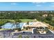 Aerial view shows a community with tennis courts, pool, and clubhouse amidst lush greenery at 8320 Creekview Ln, Englewood, FL 34224