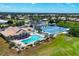 Aerial view features a community pool, tennis courts, and clubhouse with lush green surroundings at 8320 Creekview Ln, Englewood, FL 34224