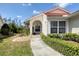 Inviting front entrance featuring an arched entryway, manicured hedges, and a tiled roof at 8320 Creekview Ln, Englewood, FL 34224