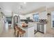 Open kitchen design with stainless appliances, center island, and open layout to dining and living area at 8320 Creekview Ln, Englewood, FL 34224