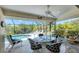 Screened lanai features a ceiling fan and a stylish table set with views of the refreshing outdoor pool at 8320 Creekview Ln, Englewood, FL 34224