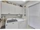 Bright laundry room with modern washer and dryer units and custom cabinetry at 8320 Creekview Ln, Englewood, FL 34224