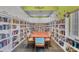 Charming library with extensive bookshelves and a large table for reading or studying at 8320 Creekview Ln, Englewood, FL 34224
